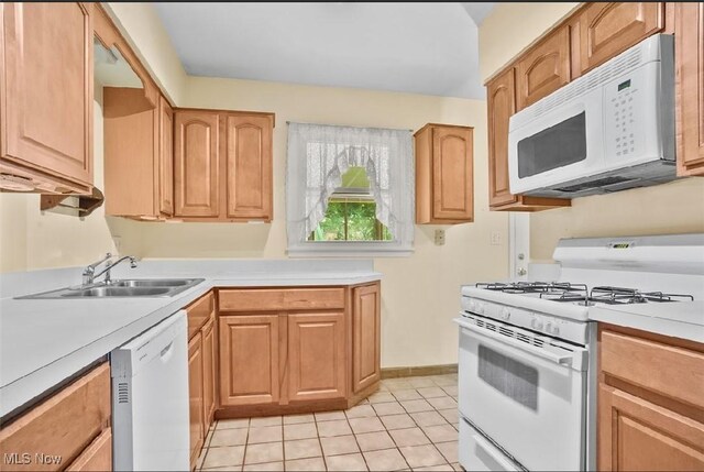 kitchen with white appliances, sink, and light tile patterned flooring