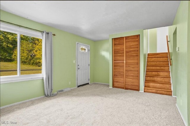 unfurnished bedroom with carpet flooring, a closet, and multiple windows