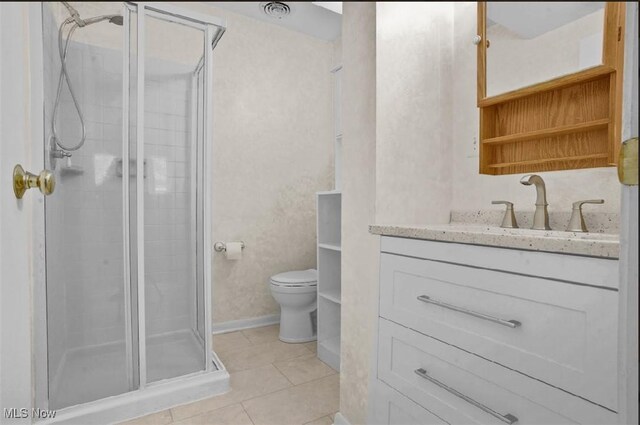 bathroom with vanity, toilet, a shower with shower door, and tile patterned floors