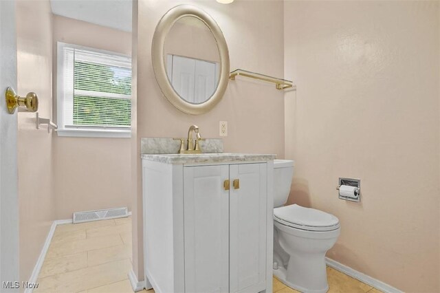 bathroom with vanity, toilet, and tile patterned floors