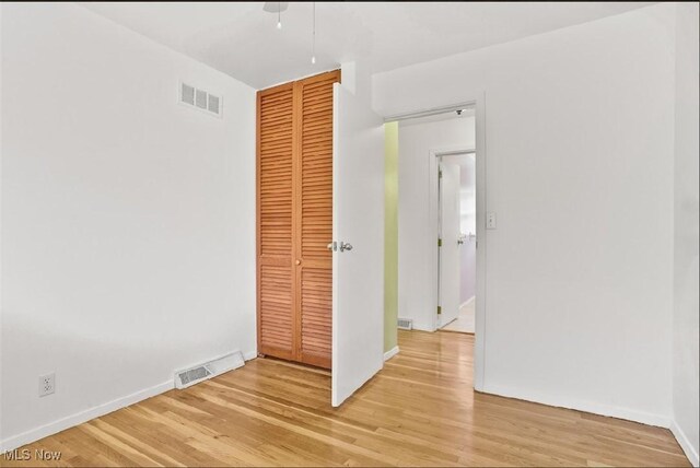 unfurnished bedroom with a closet and light hardwood / wood-style floors