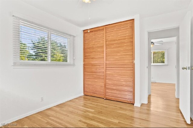 unfurnished bedroom with a closet and light hardwood / wood-style floors