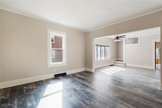 empty room with baseboards, visible vents, wood finished floors, and a ceiling fan
