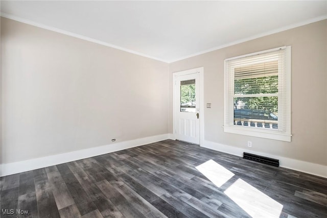spare room featuring dark wood-style floors, visible vents, and crown molding