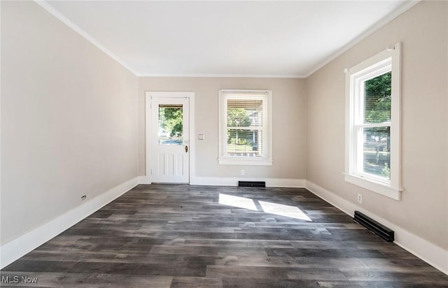 interior space with baseboards, visible vents, crown molding, and dark wood finished floors