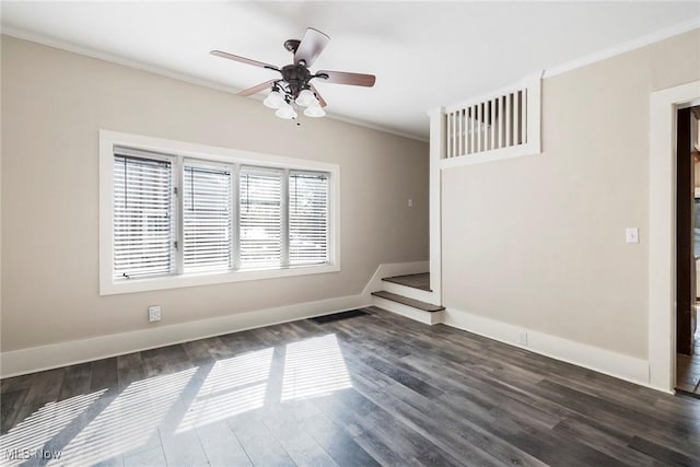 spare room featuring a ceiling fan, crown molding, baseboards, and dark wood finished floors
