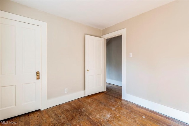 unfurnished bedroom with baseboards and wood-type flooring