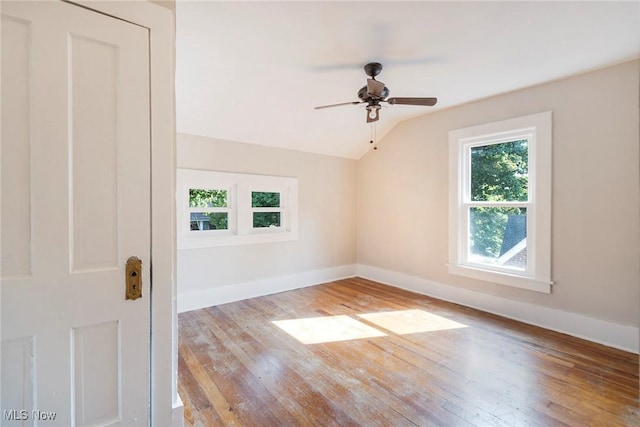 empty room with hardwood / wood-style floors, baseboards, lofted ceiling, and ceiling fan