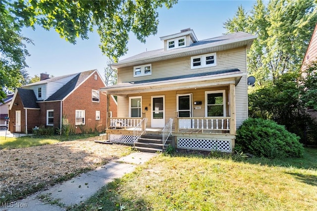 traditional style home featuring a front yard and a porch