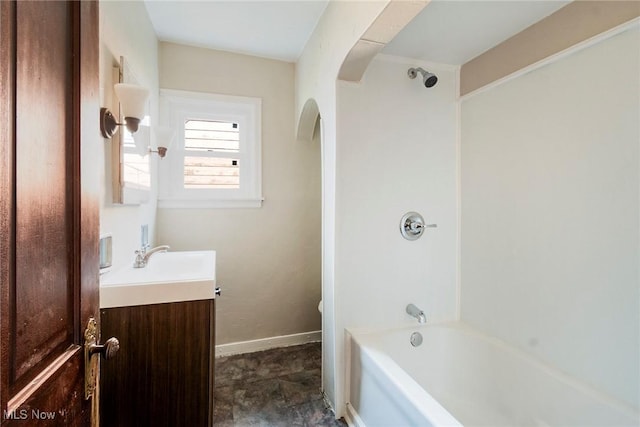 bathroom with toilet, vanity, shower / bathtub combination, and baseboards