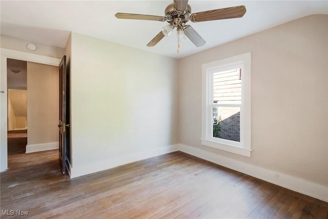 spare room featuring baseboards, ceiling fan, and hardwood / wood-style flooring