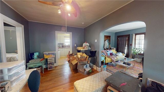 living room featuring crown molding, plenty of natural light, ceiling fan, and hardwood / wood-style flooring