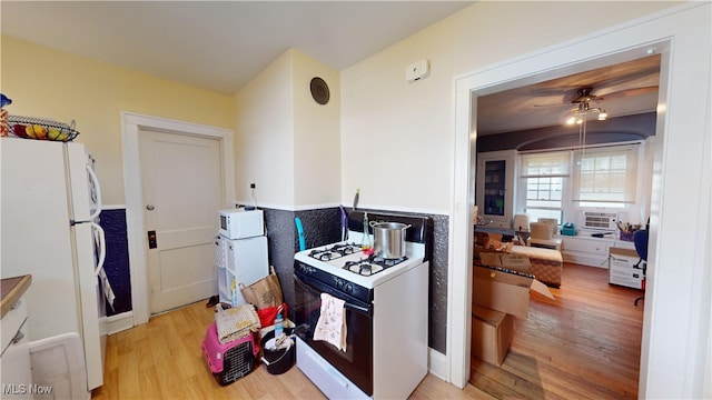 kitchen with light hardwood / wood-style flooring, white appliances, and ceiling fan