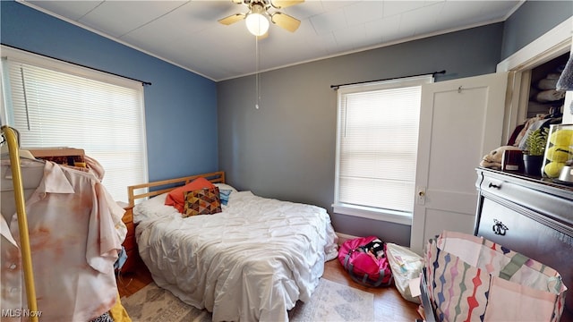 bedroom with crown molding, ceiling fan, and hardwood / wood-style floors