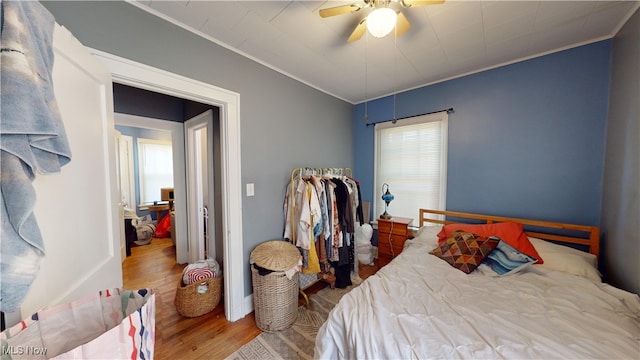 bedroom with ceiling fan, ornamental molding, and hardwood / wood-style flooring