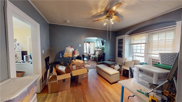 living room with ornamental molding, ceiling fan, and light hardwood / wood-style floors