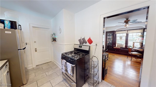 kitchen with light hardwood / wood-style flooring, appliances with stainless steel finishes, and ceiling fan