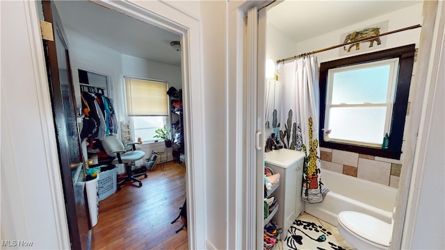 bathroom with toilet, shower / tub combo with curtain, and hardwood / wood-style floors