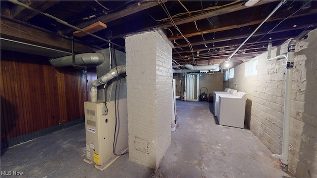 basement featuring heating unit and washing machine and clothes dryer