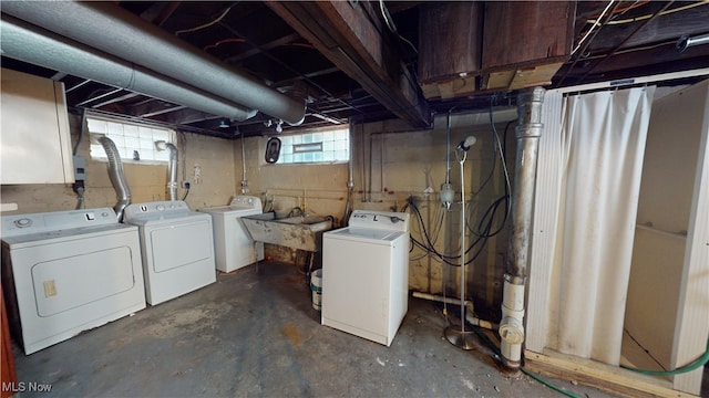 basement with sink, washer and clothes dryer, and a healthy amount of sunlight