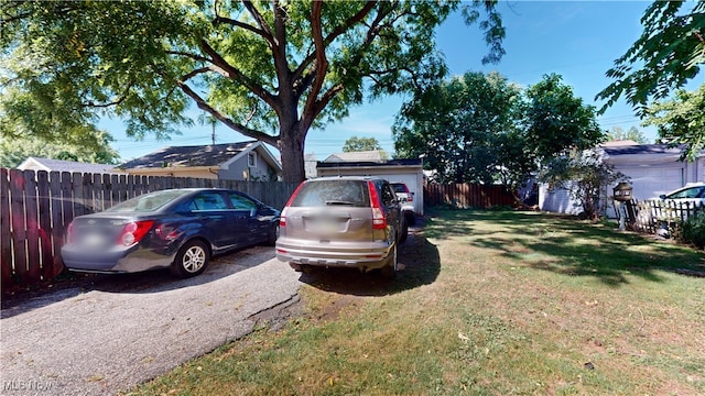 view of vehicle parking with a yard