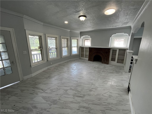 unfurnished living room featuring a textured ceiling, ornamental molding, and a brick fireplace