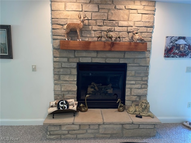 interior details featuring a stone fireplace and carpet floors