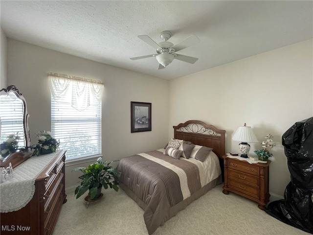 carpeted bedroom with multiple windows, ceiling fan, and a textured ceiling