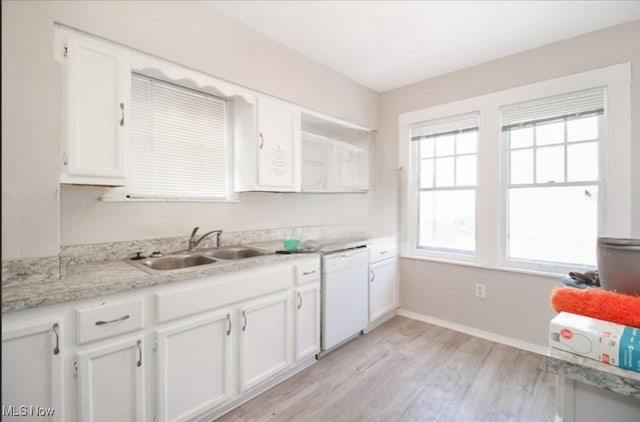 kitchen with light wood-type flooring, white cabinets, dishwasher, and sink