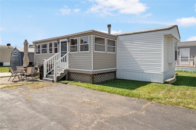 view of front of property featuring a front lawn and a patio