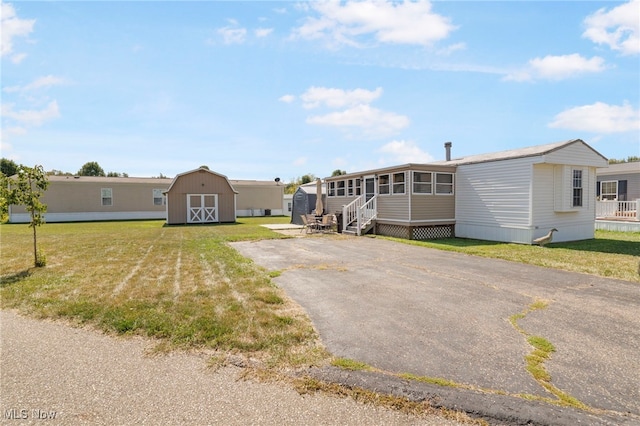 manufactured / mobile home with a storage shed and a front yard