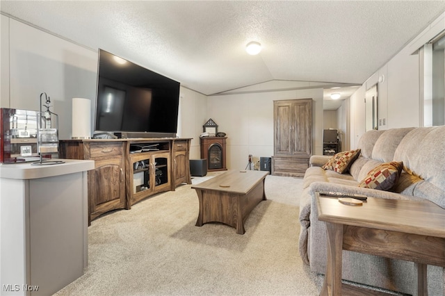 carpeted living room with a textured ceiling and vaulted ceiling