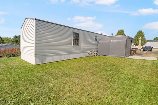 view of side of home with a yard