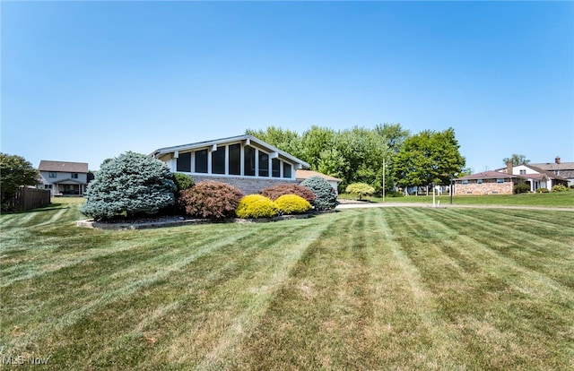 view of side of home featuring a sunroom and a yard