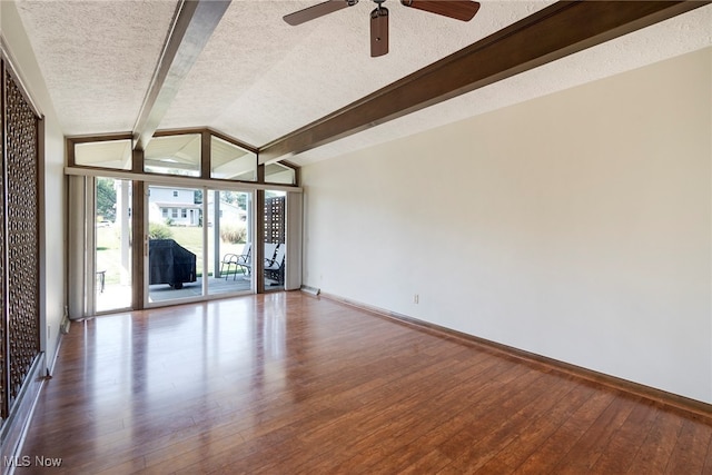 empty room with a textured ceiling, dark hardwood / wood-style flooring, ceiling fan, and vaulted ceiling with beams