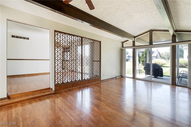 empty room featuring a textured ceiling, plenty of natural light, and wood-type flooring