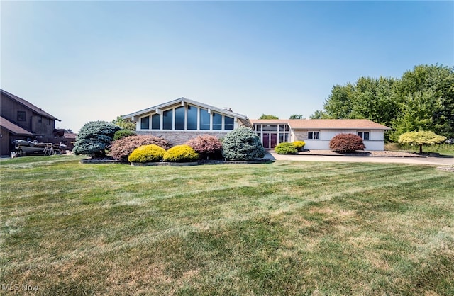 ranch-style house with a front yard and a sunroom