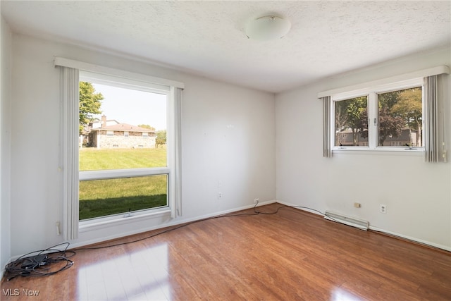 unfurnished room featuring hardwood / wood-style floors and a textured ceiling