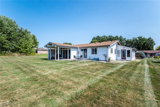 rear view of house with a yard and a patio