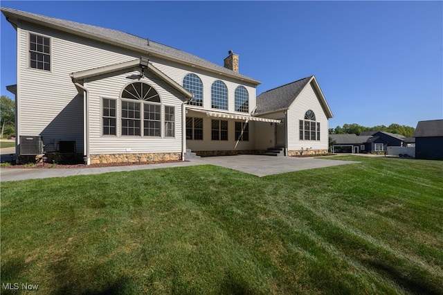 back of property featuring a lawn and a patio area