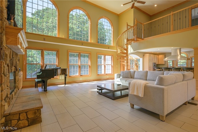 living room with a high ceiling, ceiling fan, and a fireplace