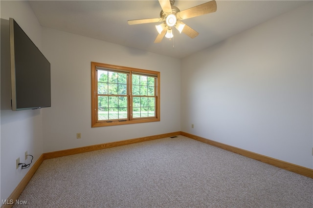 carpeted spare room featuring ceiling fan