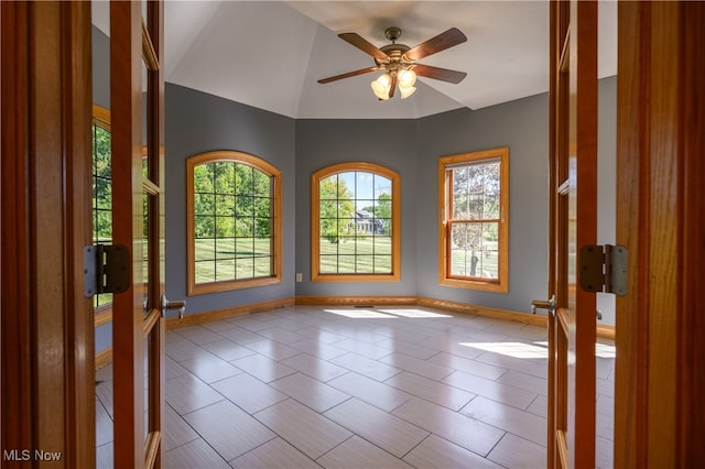 spare room featuring lofted ceiling, light tile patterned floors, and ceiling fan