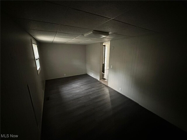 interior space with a paneled ceiling and hardwood / wood-style floors