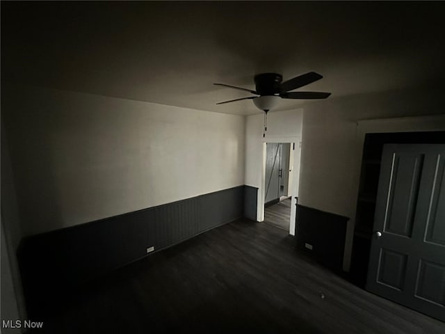 spare room featuring dark wood-type flooring and ceiling fan