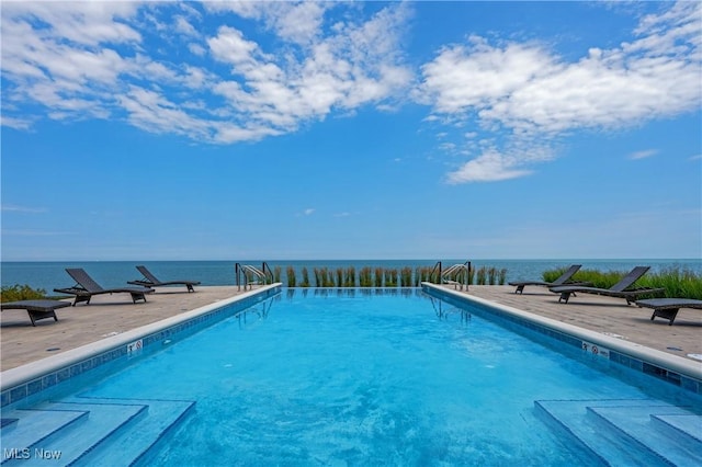 view of swimming pool with a patio and a water view