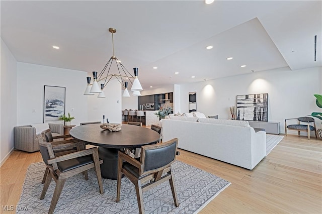 dining area featuring a notable chandelier and light hardwood / wood-style floors