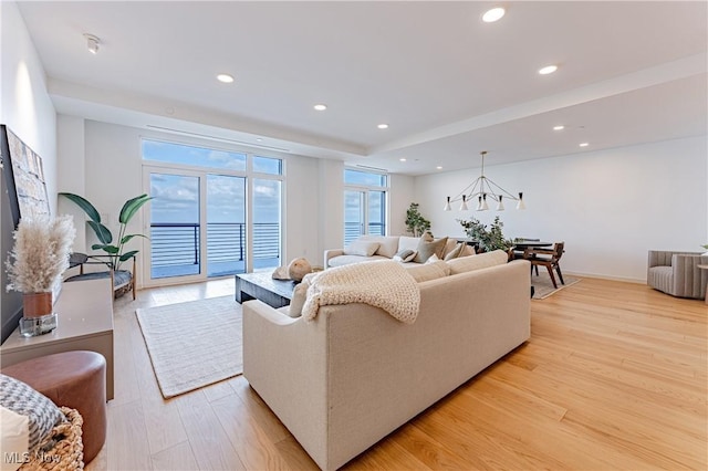 living room with light hardwood / wood-style flooring and a chandelier