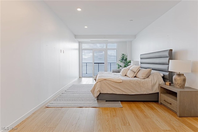 bedroom featuring access to exterior and light hardwood / wood-style flooring