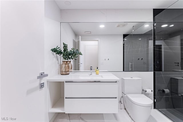 bathroom with vanity, toilet, and a shower with door